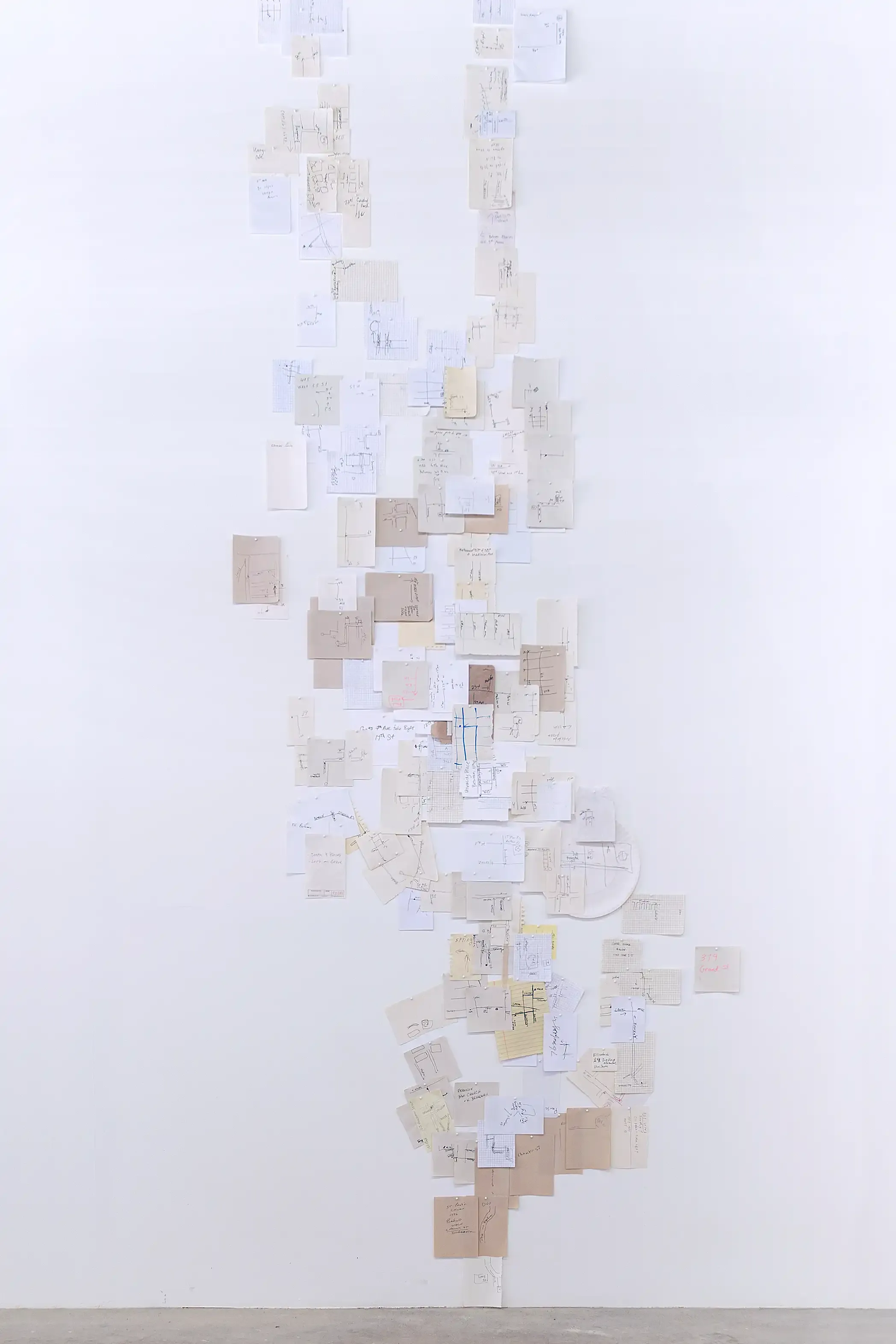 A map of Manhattan made up of pieces of scrap paper that contain directions given by strangers corresponding to their location in the map.