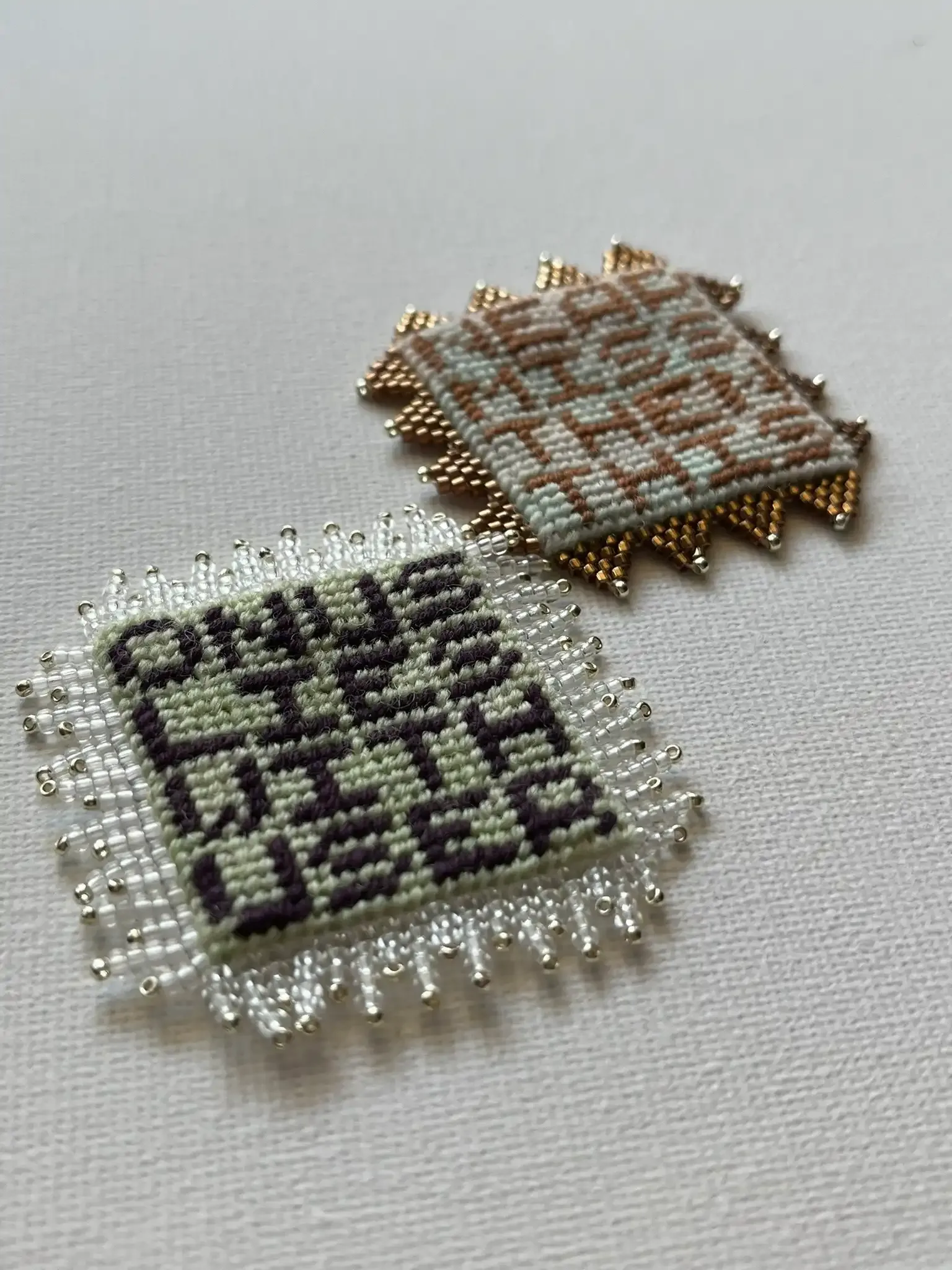Two embroidered squares that look like they have chip connectors on the edges. They read: "Onus lies with user" and "Near miss, then this".